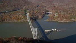 5.5K aerial stock footage of flying over forest in Autumn, reveal oil tanker sailing toward a bridge, Westchester County, New York Aerial Stock Footage | AX119_151E
