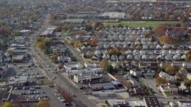 5.5K aerial stock footage of suburbs, sports fields and stores along a busy street in Autumn, Elmont, New York Aerial Stock Footage | AX120_035E