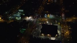 5.5K aerial stock footage approach shops by a city street in Jersey City, New Jersey, at Night Aerial Stock Footage | AX122_004