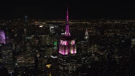 5.5K aerial stock footage orbit the rooftop of Empire State Building as it lights up at Night in Midtown, New York City Aerial Stock Footage | AX122_085E