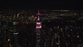 5.5K aerial stock footage circle the Empire State Building with pink and white lights at Nighttime, Midtown, NYC Aerial Stock Footage | AX122_102