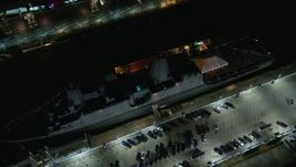 5.5K aerial stock footage orbit and tilt to bird's eye of a Naval Warship at Hell's Kitchen docks at Night in Midtown, NYC Aerial Stock Footage | AX123_007E