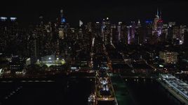5.5K aerial stock footage of Midtown skyscrapers seen from a cruise ship docked in Hell's Kitchen at Night, NYC Aerial Stock Footage | AX123_011E
