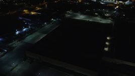 5.5K aerial stock footage approach dark warehouse at Night in Farmingdale, New York Aerial Stock Footage | AX123_189E
