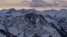 5.5K aerial stock footage of the summit of a snowy Wasatch Range peak in Winter at Sunrise in Utah Aerial Stock Footage | AX124_040E