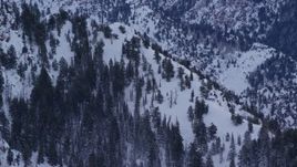 5.5K aerial stock footage of a snowy slope of Mount Olympus at winter sunrise in Utah Aerial Stock Footage | AX124_048E