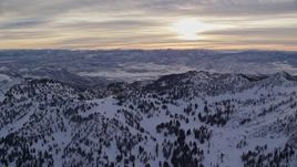 5.5K aerial stock footage of the sunrise seen while orbiting Wasatch Range snow mountains in Utah Aerial Stock Footage | AX124_077E