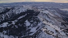 5.5K aerial stock footage fly over snowy mountain ridge at sunrise in Wasatch Range, Utah Aerial Stock Footage | AX124_080E