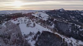 5.5K aerial stock footage of snowy mountain slops with trees in winter at sunrise in the Wasatch Range, Utah Aerial Stock Footage | AX124_105E