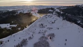 5.5K aerial stock footage of a snowdrift plume on a wintery mountain peak at sunrise in Utah's Wasatch Range Aerial Stock Footage | AX124_110E