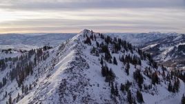 5.5K aerial stock footage fly over Clayton Peak with winter snow and reveal valley at sunrise in the Wasatch Range, Utah Aerial Stock Footage | AX124_121E