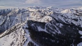 5.5K aerial stock footage pan across snow mountains in Wasatch Range at sunrise in Utah Aerial Stock Footage | AX124_124E