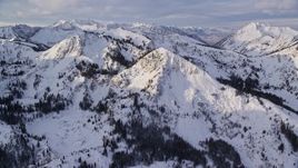 5.5K aerial stock footage of peaks with wintertime snow at sunrise in the Wasatch Range, Utah Aerial Stock Footage | AX124_128E