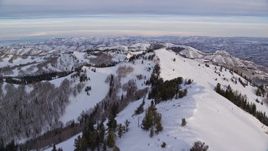 5.5K aerial stock footage fly over the top of a snow mountain at sunrise in Utah's Wasatch Range Aerial Stock Footage | AX124_137E