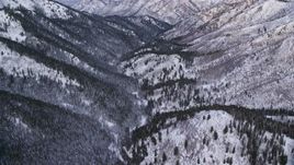 5.5K aerial stock footage approach the base of snowy mountains at sunrise in the Wasatch Range, Utah Aerial Stock Footage | AX124_147E