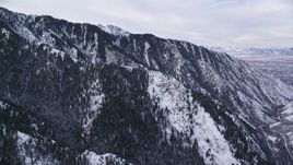 5.5K aerial stock footage of snowy mountain ridges with trees at winter sunrise in Utah's Wasatch Range Aerial Stock Footage | AX124_167E