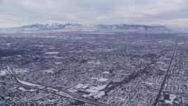5.5K aerial stock footage of Salt Lake City suburbs and Oquirrh Mountains in winter snow at sunrise, Utah Aerial Stock Footage | AX124_178E