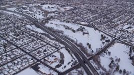 5.5K aerial stock footage follow light traffic on Interstate 80 through snowy Salt Lake City at sunrise, Utah Aerial Stock Footage | AX124_187E