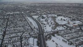 5.5K aerial stock footage orbit Interstate 80 through snowy Salt Lake City, tilt to wide view of the city at sunrise, Utah Aerial Stock Footage | AX124_188
