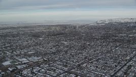 5.5K aerial stock footage fly over suburban homes with snow toward Downtown Salt Lake City at sunrise in Utah Aerial Stock Footage | AX124_189