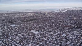 5.5K aerial stock footage fly over suburban homes with snow toward Downtown Salt Lake City at sunrise in Utah Aerial Stock Footage | AX124_189E