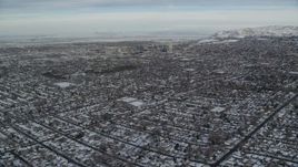 5.5K aerial stock footage fly over suburbs with winter snow to approach Downtown Salt Lake City at sunrise in Utah Aerial Stock Footage | AX124_190