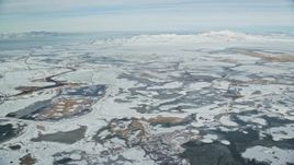 5.5K aerial stock footage fly over frozen marshlands to approach snowy Antelope Island in winter, Utah Aerial Stock Footage | AX125_018