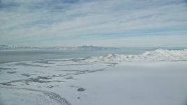 5.5K aerial stock footage of Great Salt Lake and Antelope Island with snow mountains in winter in Utah Aerial Stock Footage | AX125_026