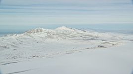5.5K aerial stock footage pan across snow mountains on Antelope Island in wintery Utah Aerial Stock Footage | AX125_029
