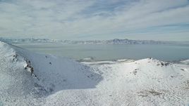5.5K aerial stock footage of Great Salt Lake seen from Antelope Island mountains in winter, Utah Aerial Stock Footage | AX125_037