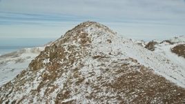 5.5K aerial stock footage approach and fly over stony mountain peak with winter snow, Antelope Island, Utah Aerial Stock Footage | AX125_079E