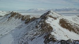 5.5K aerial stock footage of flying over rocky ridge with winter snow on Antelope Island, Utah Aerial Stock Footage | AX125_081E