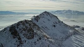 5.5K aerial stock footage approach and fly over snowy peak near shore of Great Salt Lake, Antelope Island, Utah Aerial Stock Footage | AX125_096E