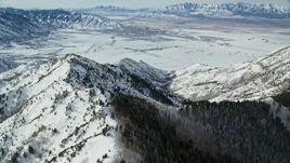 5.5K aerial stock footage fly over Oquirrh Mountains to approach wintery small town in Utah Aerial Stock Footage | AX125_147