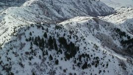 5.5K aerial stock footage fly over and orbit snowy ridges and slopes in wintertime, Oquirrh Mountains, Utah Aerial Stock Footage | AX125_152