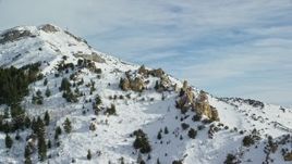 5.5K aerial stock footage orbit jagged rocks on a snowy mountain peak in winter, Oquirrh Mountains, Utah Aerial Stock Footage | AX125_153