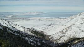 5.5K aerial stock footage of Great Salt Lake seen from snowy Oquirrh Mountains, Utah Aerial Stock Footage | AX125_154
