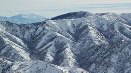 5.5K aerial stock footage of Oquirrh Mountains slopes with light snow in wintertime Utah Aerial Stock Footage | AX125_163