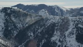 5.5K aerial stock footage orbit Oquirrh Mountains ridge with snowdrifts in winter, Utah Aerial Stock Footage | AX125_171