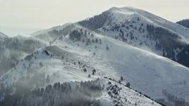 5.5K aerial stock footage of snowdrift plumes rising from Oquirrh Mountains peaks in winter, Utah Aerial Stock Footage | AX125_180E