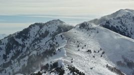 5.5K aerial stock footage slowly approach snowdrifts from a peak in the Oquirrh Mountains, Utah Aerial Stock Footage | AX125_187