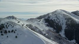 5.5K aerial stock footage of two peaks with snowdrifts in the Oquirrh Mountains or Utah in winter Aerial Stock Footage | AX125_192