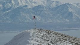 5.5K aerial stock footage orbit American flag on summit of snowy Oquirrh Mountains peak, Utah Aerial Stock Footage | AX125_211