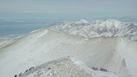 5.5K aerial stock footage fly over one Oquirrh Mountains ridge to approach second ridge in winter, Utah Aerial Stock Footage | AX125_217E