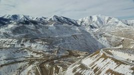 5.5K aerial stock footage of the outer rim of the Bingham Canyon Copper Mine and gravel haulers in winter, Utah Aerial Stock Footage | AX125_239E