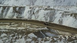 5.5K aerial stock footage of tracking a gravel hauler at the Bingham Canyon Mine in snowy Utah Aerial Stock Footage | AX125_241