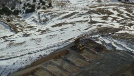 5.5K aerial stock footage of hauler dumping gravel at the Bingham Canyon Mine in winter, Utah Aerial Stock Footage | AX125_250E