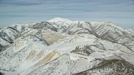 5.5K aerial stock footage of an open pit mine with winter snow in the Oquirrh Mountains, Utah Aerial Stock Footage | AX125_271E