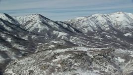 5.5K aerial stock footage orbit small domed mountain near snowy peaks in winter, Oquirrh Mountains, Utah Aerial Stock Footage | AX125_281