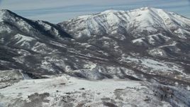 5.5K aerial stock footage orbit flat summit near snowy mountain peaks in winter, Oquirrh Mountains, Utah Aerial Stock Footage | AX125_283